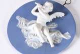 Três peças de biscuit Wedgwood, sendo: Ânfora n... - Três peças de biscuit Wedgwood, sendo: Ânfora na cor verde (alça colada e bicados na base); placa azul com figura de anjo flautista (colada) e p...