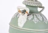 Três peças de biscuit Wedgwood, sendo: Ânfora n... - Três peças de biscuit Wedgwood, sendo: Ânfora na cor verde (alça colada e bicados na base); placa azul com figura de anjo flautista (colada) e p...