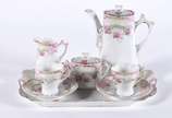 Tête-à-tête de porcelana branca decorada com gu... - Tête-à-tête de porcelana branca decorada com guirlandas florais com rosas e realces dourados, composto de 6 peças, sendo bule, leiteira, açucare...