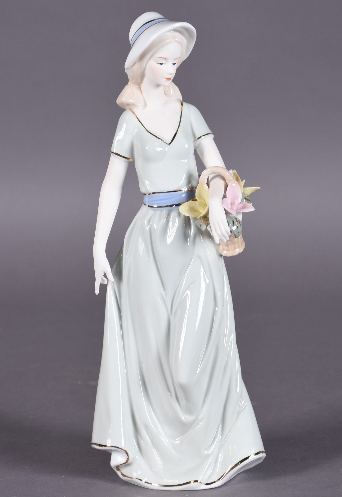 Estatueta de porcelana policromada representando dama com cesto de... - foto 1 de 4