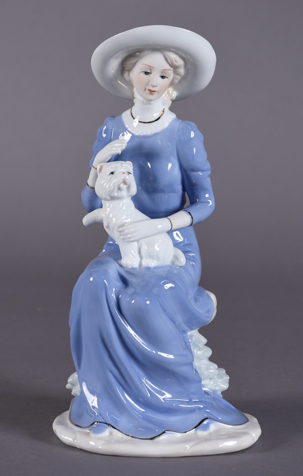 Estatueta de porcelana policromada representando dama com cachorro. - foto 1 de 4