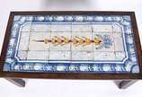 Mesa de centro de madeira nobre, feitio retangu... - Mesa de centro de madeira nobre, feitio retangular com tampo coberto por azulejos do Maranhão em azul e branco com guirlanda floral amarela ao c...