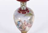 Ânfora em porcelana francesa de Sèvres, fundo n... - Ânfora em porcelana francesa de Sèvres, fundo na cor vinho com cena romântica em policromia, realces dourados, assinada, restauro na tampa e no ...
