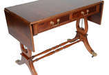 Mesa inglesa de madeira nobre, abas laterais, d... - Mesa inglesa de madeira nobre, abas laterais, duas gavetas, pernas feitio lira, ponteiras de bronze sobre rodízios. 