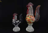 Duas estatuetas em murano rep. Galo em tons mes... - Duas estatuetas em murano rep. Galo em tons mesclados. Alt. 20 e 30 cm
