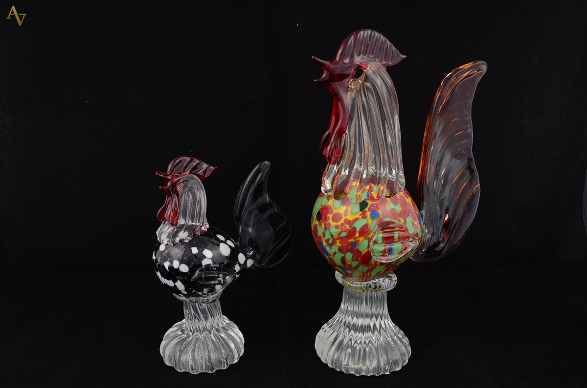 Duas estatuetas em murano rep. Galo em tons mesclados. Alt. 20 e 30 cm