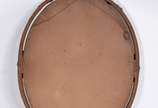 Espelho oval com moldura de madeira patinada em... - Espelho oval com moldura de madeira patinada em dourado com entalhes e guirlandas florais. Espelho com pequenas partes oxidadas.