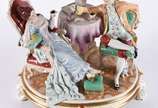 Grupo escultórico de porcelana tcheca Royal Dux... - Grupo escultórico de porcelana tcheca Royal Dux policromada com realces dourados representando casal tomando chá. Alça do bule colada e pequenos...