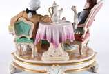 Grupo escultórico de porcelana tcheca Royal Dux... - Grupo escultórico de porcelana tcheca Royal Dux policromada com realces dourados representando casal tomando chá. Alça do bule colada e pequenos...