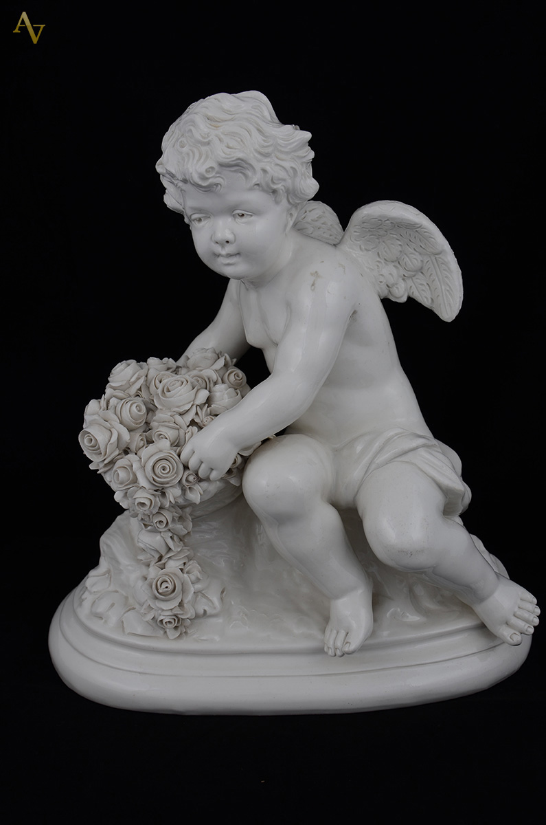 Escultura em porcelana branca rep. Anjo sentado em um tronco de...