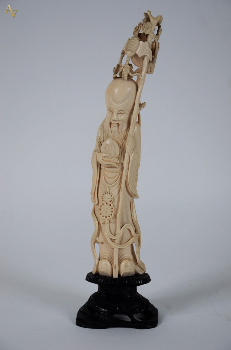 Estatueta em marfim rep. figura com cajado. Alt. 37 cm