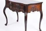 Mesa de encostar de madeira nobre com 2 gavetas... - Mesa de encostar de madeira nobre com 2 gavetas emolduradas, puxadores de metal, pequena aba recortada com entalhes rasos e ilhargas com decoraç...