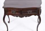 Mesa de encostar de madeira nobre com 2 gavetas... - Mesa de encostar de madeira nobre com 2 gavetas emolduradas, puxadores de metal, pequena aba recortada com entalhes rasos e ilhargas com decoraç...