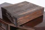 Mesa de encostar de madeira nobre com 2 gavetas... - Mesa de encostar de madeira nobre com 2 gavetas emolduradas, puxadores de metal, pequena aba recortada com entalhes rasos e ilhargas com decoraç...