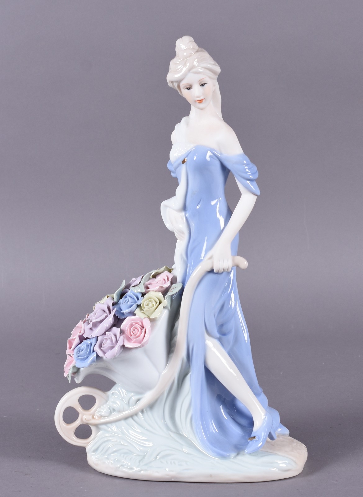 Escultura de porcelana representando dama com carrinho de flores. - foto 1 de 5