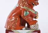 Cão de fó de porcelana chinesa na cor "Rouge de... - Cão de fó de porcelana chinesa na cor "Rouge de fer" com detalhes em policromia e realces dourados, sobre base retangular em tons de vinho. Cons...