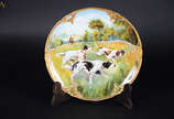 Prato em porcelana policromada com figuras de c... - Prato em porcelana policromada com figuras de cachorros. 22 cm diâm.