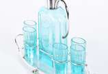 Conjunto composto de licoreira e 6 copinhos de ... - Conjunto composto de licoreira e 6 copinhos de cristal facetado na cor verde, alça, bocal e bandeja de metal prateado.