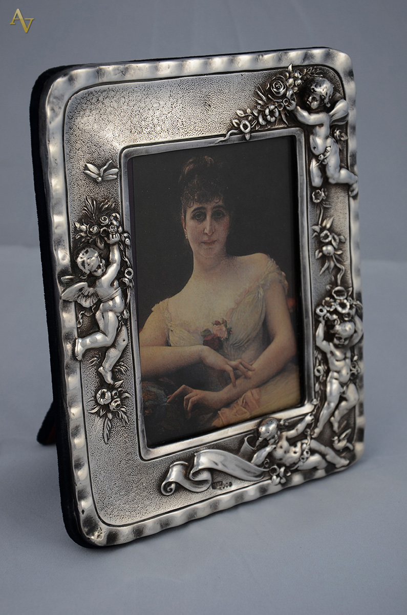 Porta retrato em prata decorado c/ anjos em relevo, med.externa 21 x...