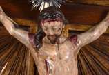 Crucifixo português de madeira nobre com figura... - Crucifixo português de madeira nobre com figura de Cristo ricamente entalhada e policromada, placa e resplendor de prata, século XIX.