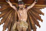 Crucifixo português de madeira nobre com figura... - Crucifixo português de madeira nobre com figura de Cristo ricamente entalhada e policromada, placa e resplendor de prata, século XIX.