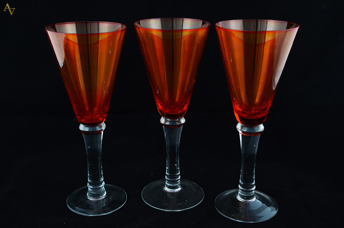 Seis cálices para vinho de vidro na cor laranja.