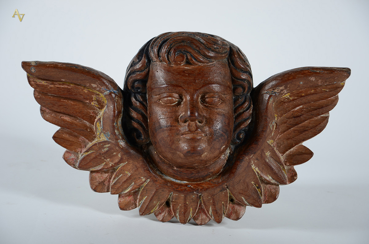 Cabeça de anjo de madeira entalhada. Alt. 25 cm - larg. 40 cm.