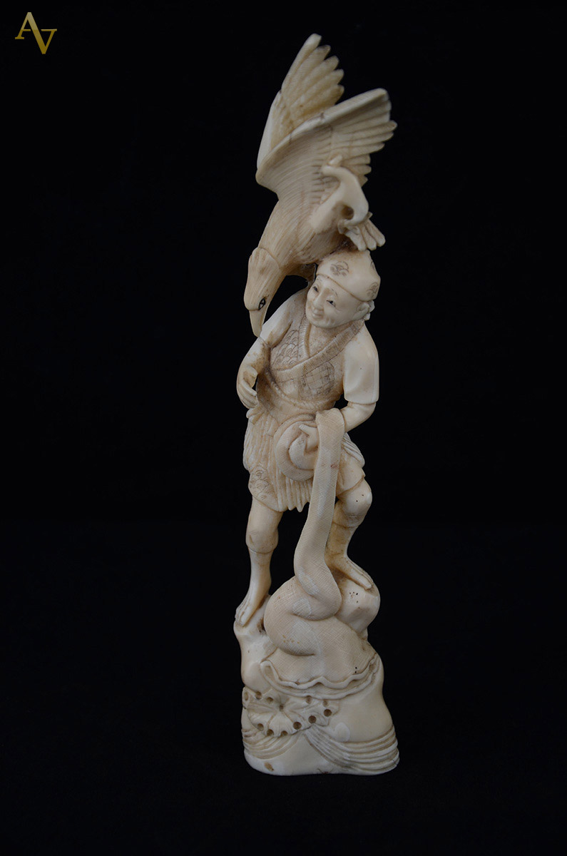 Estatueta de marfim representando figura feminina com pássaro. Alt...