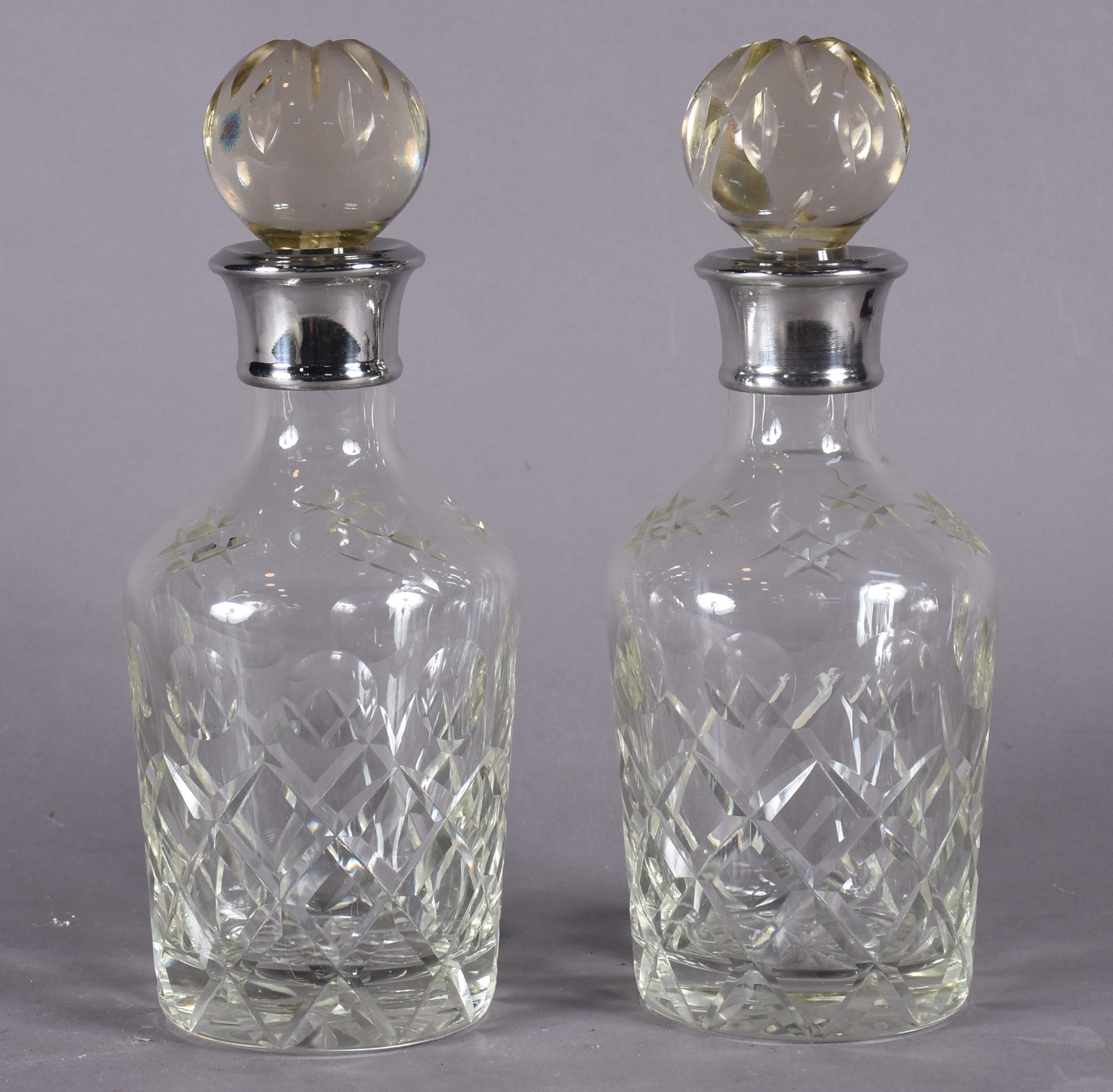 Par de garrafas de cristal lapidado com bocais de metal prateado (as... - foto 1 de 6