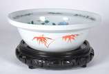 Bacia circular em porcelana chinesa, com bordas... - Bacia circular em porcelana chinesa, com bordas reviradas, ornada em policromia com arranjos florais e laterais externas com folhas de bambu est...
