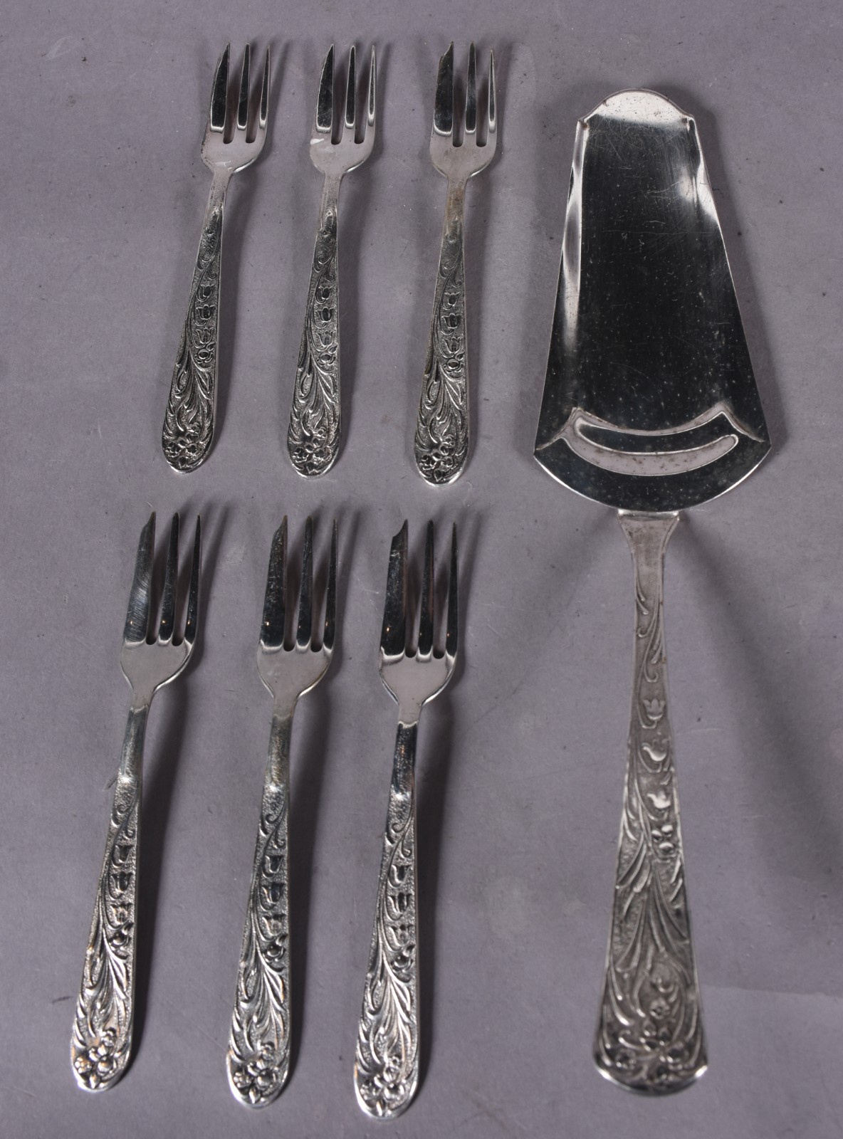 Conjunto para bolo de metal prateado composto de: 6 garfos e... - foto 1 de 4