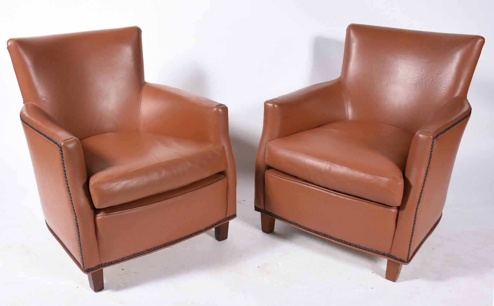 Par de pequenas poltronas, estofadas na cor caramelo com tacheados. - foto 1 de 7