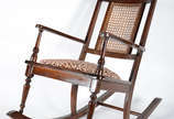 Cadeira de balanço de madeira nobre frisada, de... - Cadeira de balanço de madeira nobre frisada, detalhes com pinos torneados, encosto de palhinha e assento estofado.