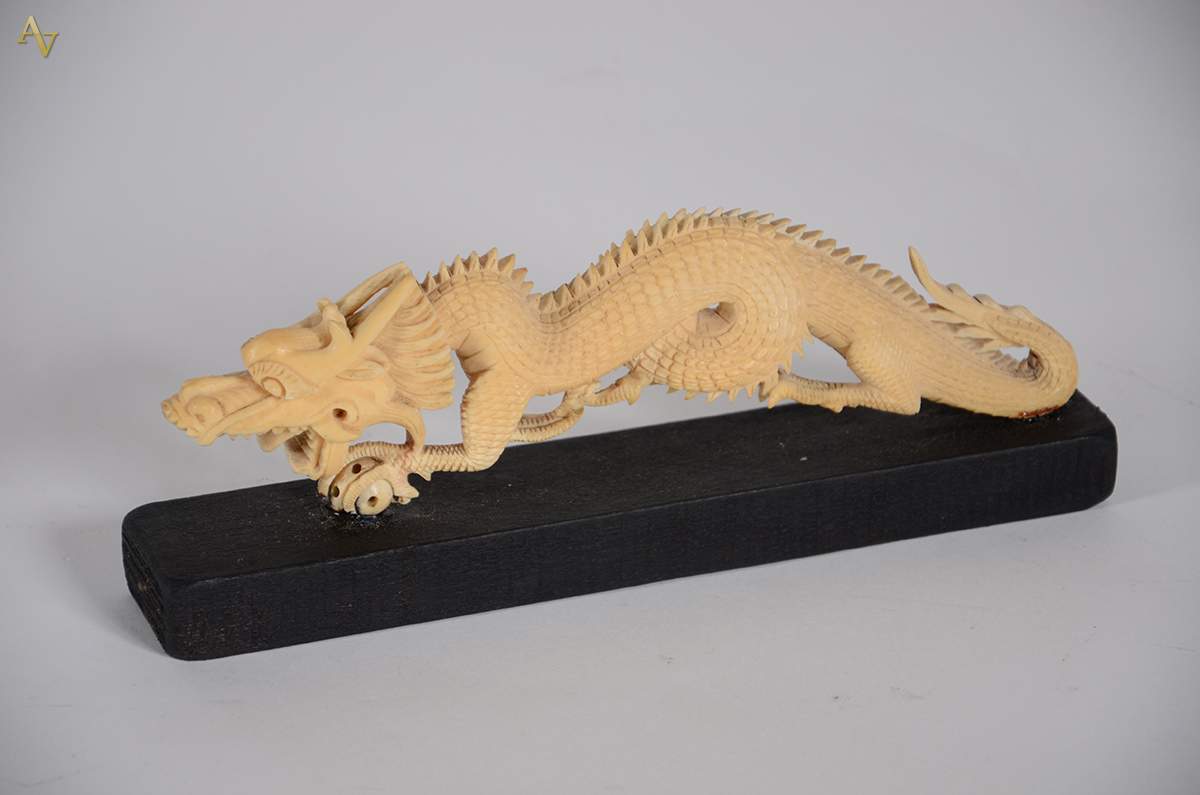 Escultura de marfim, representando dragão. Comp. 25 cm.