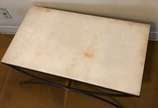 Mesa de centro com base de metal pintado de pre... - Mesa de centro com base de metal pintado de preto em forma de dois semi círculos e arremate com botão dourado,  tampo de mármore. Desgastes no m...