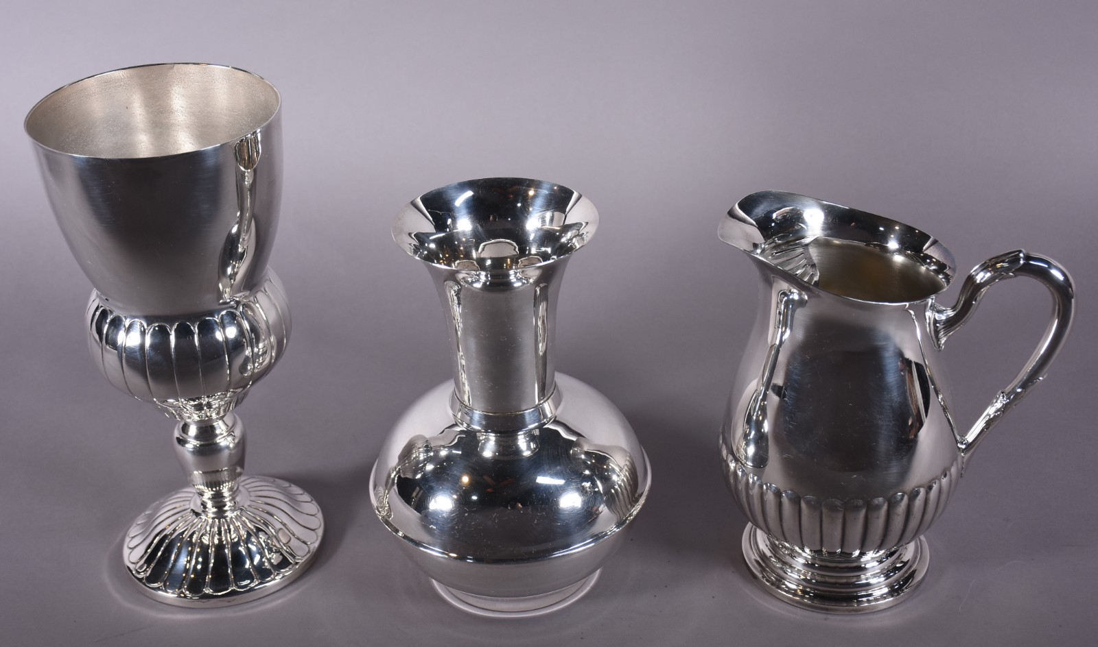 Três peças de metal prateado, sendo jarra para água e 2 vasos. - foto 2 de 6
