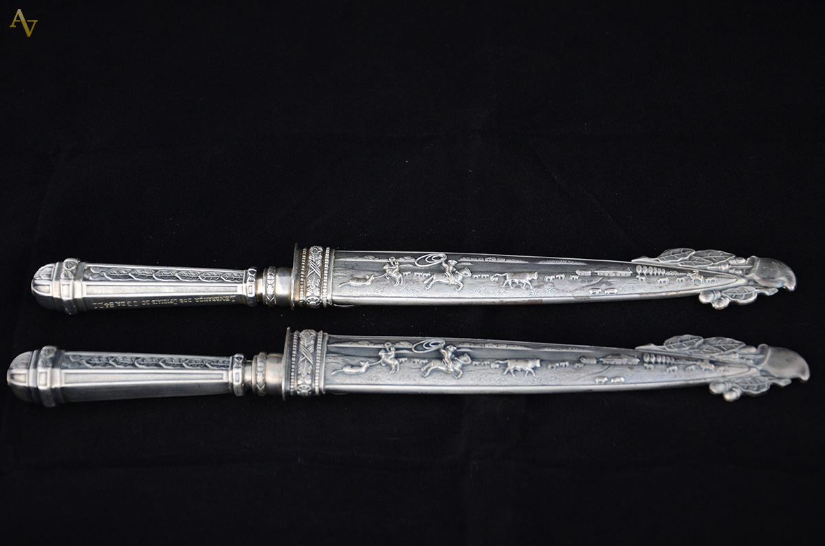 Duas facas com bainhas de metal prateado. Comp. 32 cm.