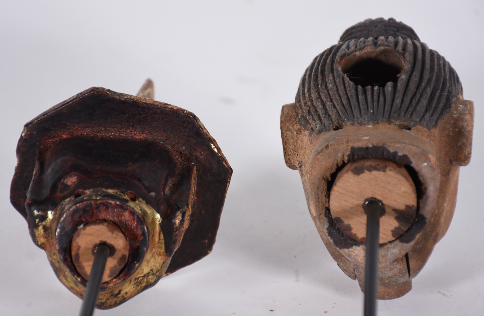 Duas cabeças de madeira entalhada sobre bases de metal, com oxidações. - foto 6 de 8