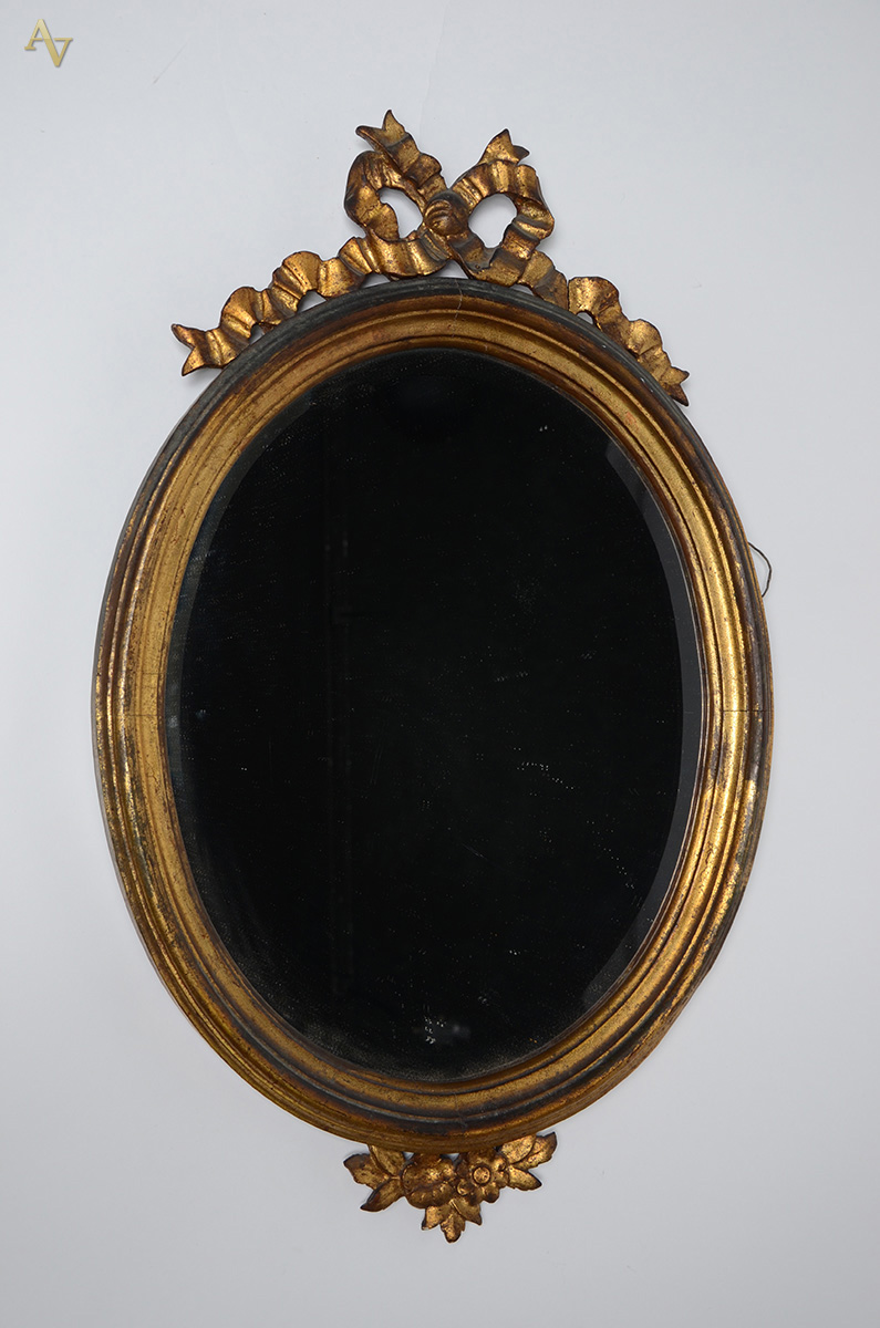 Espelho oval de cristal bisotado, moldura de madeira dourada encimada...
