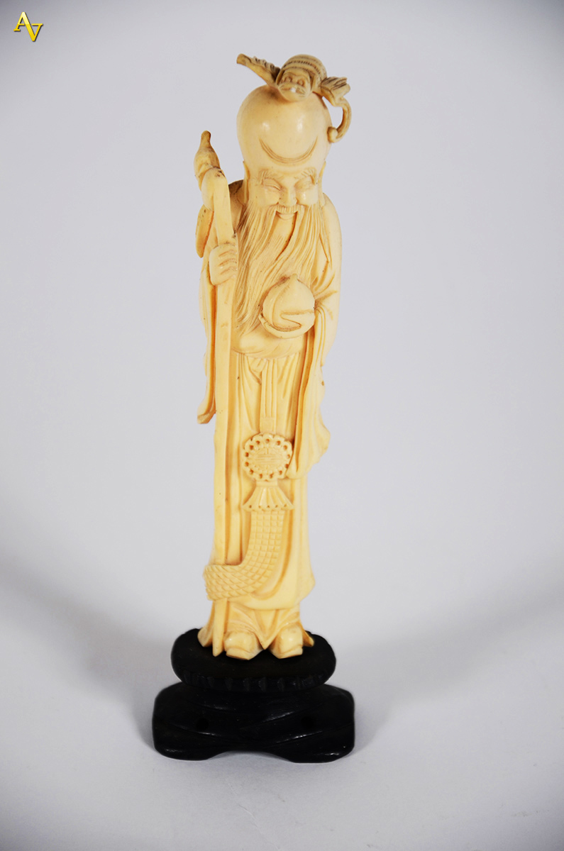 Escultura de marfim, representando sábio c/ cajado. Alt. total 24 cm