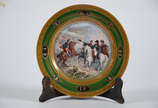 Prato de porcelana Napoleão , verso com N coroa... - Prato de porcelana Napoleão , verso com N coroado e a inscrição: Combat de Heilsberg, em policromia e borda com grega dourada. Diam. 21 cm.