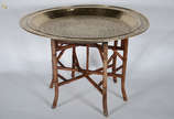 Mesa egipcia com tampo de metal dourado e base ... - Mesa egipcia com tampo de metal dourado e base articulada de madeira. . Diam. 90 cm - alt. 60 cm.