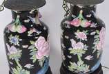 Par de abatjoures de porcelana oriental, fundo ... - Par de abatjoures de porcelana oriental, fundo preto com flores em policromia. Gargalo com frutos em relevo. Marcas na base. Acompanham peanhas ...