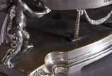 Centro de mesa de metal prateado na forma de bo... - Centro de mesa de metal prateado na forma de bowl com parte interna de cristal e laterais com guirlandas em relevo, sustentado por figuras de an...