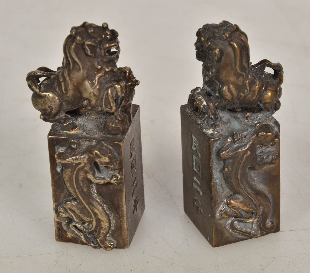 Par de selos em bronze, com figura de cão fó. Alt. 7 cm.