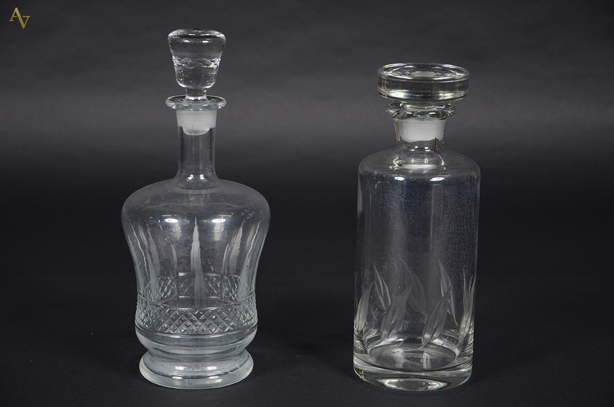 Duas garrafas em meio cristal lapidadas. Alturas 26 e 29 cm.