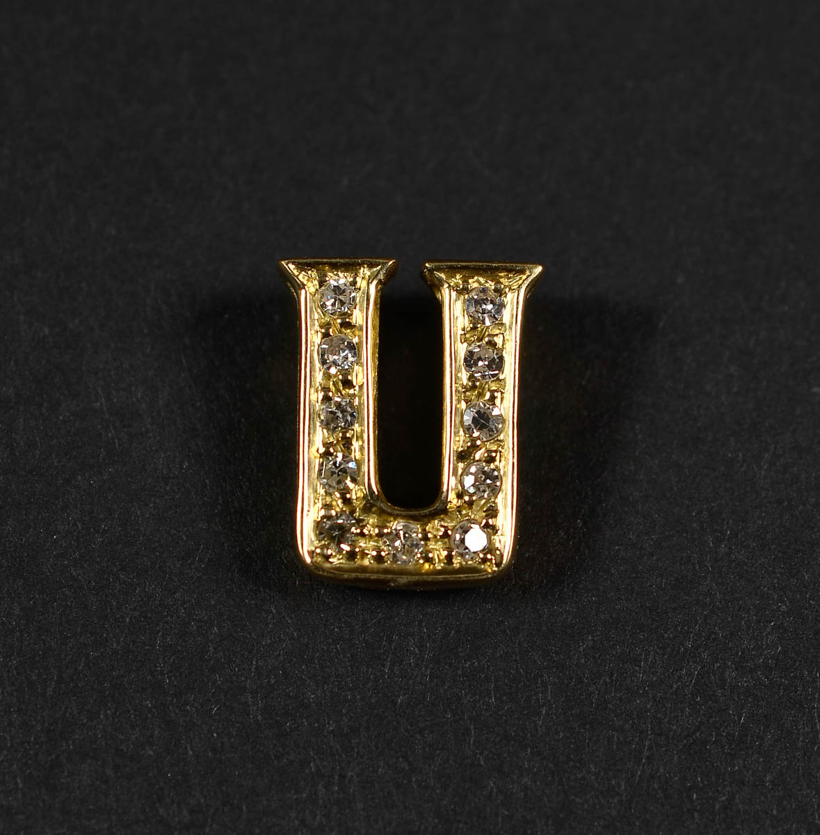 Pendente em formato de U em ouro 18 k e brilhantes. Peso total: 2 gr.