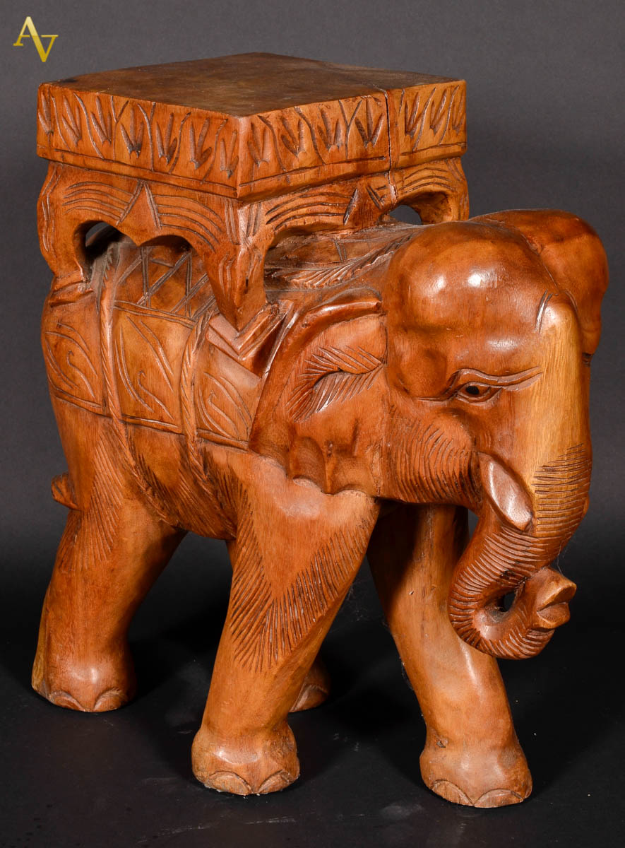 Banqueta de madeira nobre esculpida na forma de elefante. Alt. 49 cm.