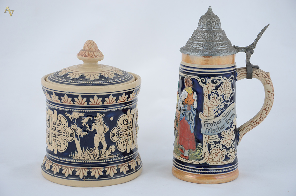 Duas peças de cerâmica alemã com figuras em relevo, sendo caneca com... - foto 1 de 2