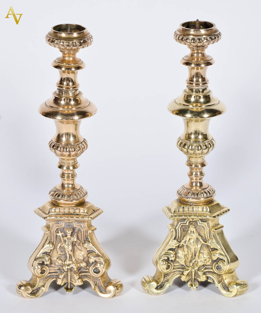 Par de castiçais de bronze com figuras sacras, alt. 27 cm.